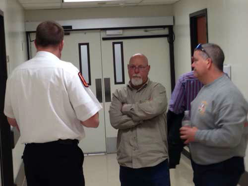 Galveston firefighters stand by in the hallways...